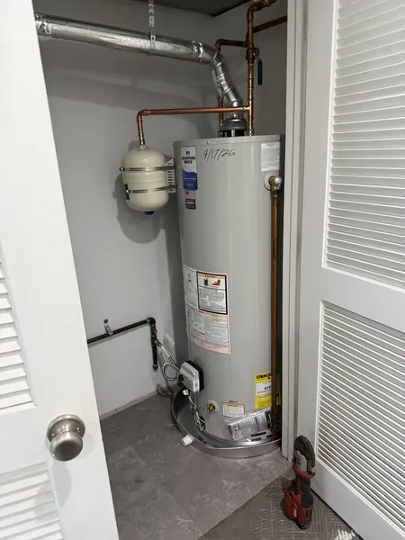 50-gallon water heater and expansion tank installed in a utility closet by Poor John's Plumbing in Overland Park